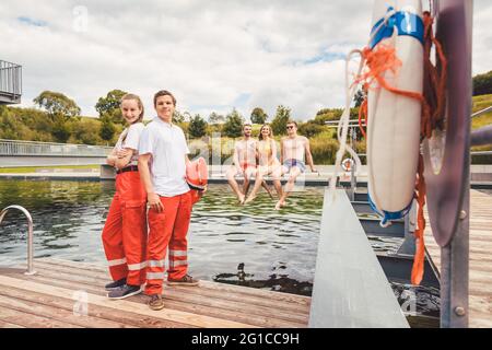 Bagnini in piedi sulla piscina pronti ad aiutare Foto Stock