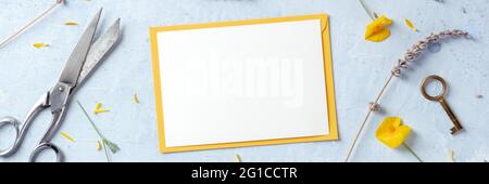Biglietto d'auguri estivo o primaverile o panorama d'invito con fiori, girato dall'alto. Mokup di cancelleria con carta bianca e lavanda Foto Stock