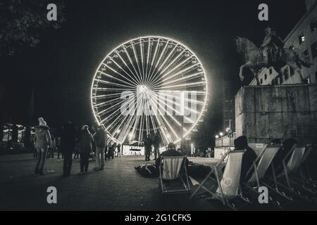 Città di Essen di notte nel tunnel. Scatto monocromatico in bianco e nero surreale. Ruota panoramica e chiaro di luna. Cratere della Luna surreale Foto Stock