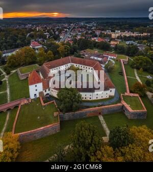 Sarvar, Ungheria - veduta aerea panoramica del Castello di Sarvar (castello di Nadaddy) in autunno dall'alto con una bella alba drammatica sullo sfondo Foto Stock