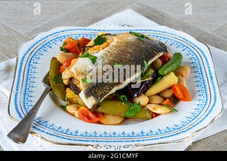 Spigola con pomodoro e ragù di fagiolo di burro Foto Stock