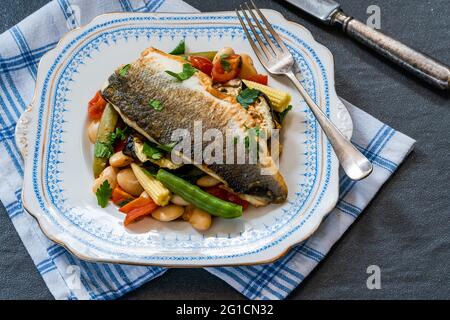 Spigola con pomodoro e ragù di fagiolo di burro Foto Stock