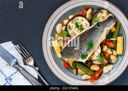 Spigola con salsa di pomodoro e burro - vista dall'alto Foto Stock