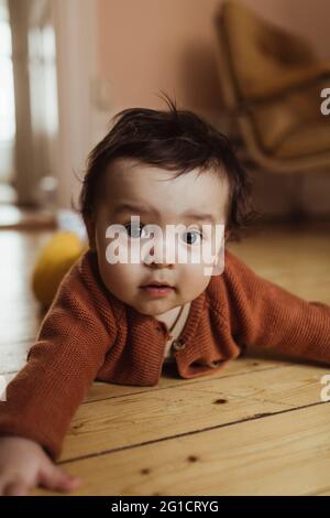 Ritratto del bambino che giace sul pavimento a casa Foto Stock