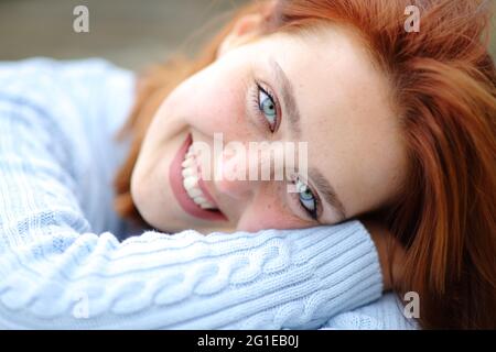 Ritratto di una bella donna con gli occhi blu sorridenti guardando la macchina fotografica Foto Stock