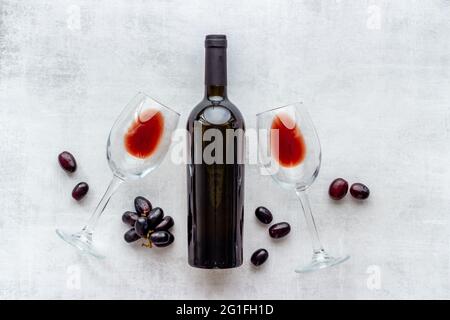 Due bicchieri di vino rosso con bottiglia e uva Foto Stock