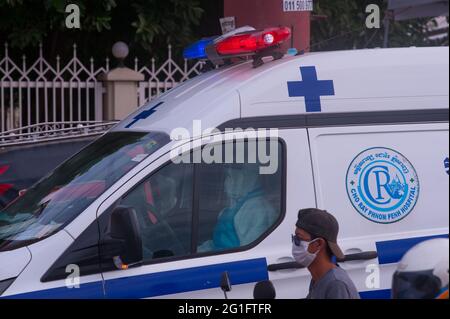 Phnom Penh, Cambogia. 7 giugno 2021. Per 3 mesi Phnom Penh sta combattendo un COVID - 19 di picco. Un'ambulanza, con un EMT che indossa PPE pieno, attende un paziente coronavirus positivo da un sito di test di massa. Credit: Kraig Lieb / Alamy Live News Foto Stock