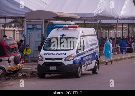 Phnom Penh, Cambogia. 7 giugno 2021. Per 3 mesi Phnom Penh sta combattendo un COVID - 19 di picco. Un'ambulanza, con entrambi EMT indossare PPE pieno, raccoglie un paziente coronavirus positivo da un sito di test di massa. Credit: Kraig Lieb / Alamy Live News Foto Stock