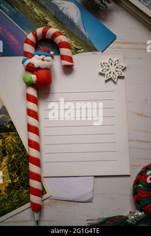 Concetto di nuovo anno. Penna a forma di caramella con Babbo Natale su notebook vuoto. Inserire il testo Foto Stock