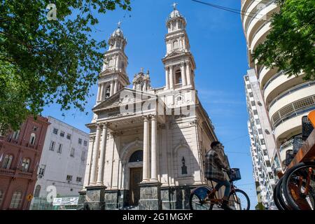 ROSARIO, ARGENTINA - 06 Ott 2020: Scatto a basso angolo della Basilica Cattedrale di nostra Signora del Rosario con un ragazzo che cavalcava una bicicletta con una maschera facciale Foto Stock