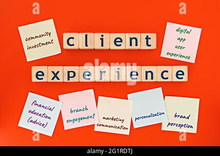 modello di esperienza del cliente. cubi di legno con le parole 'esperienza del cliente', e note appiccicose, su sfondo arancione Foto Stock