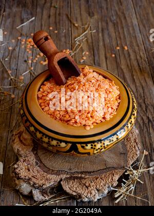 ciotola di bambù con lenticchie rosse su tavolo di legno Foto Stock