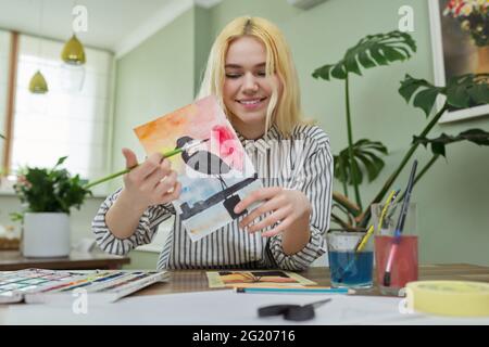 Teenage ragazza che registra video lezione di disegno, guardando e mostrando tecniche di pittura a macchina fotografica Foto Stock