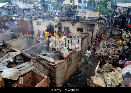Gli abitanti delle Slum del Bangladesh hanno visto la ricerca dei loro beni domestici dopo un devastante incendio scoppiato nello slum di Mohakhali a Dhaka, Bangladesh, il 7 giugno 2021. Almeno 300 shanties sono stati eviscerati come il devastante fuoco che è scoppiato a Mohakhali slum a Dhaka. Foto Stock