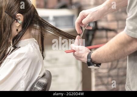Primo piano di una donna che ha un taglio di capelli con forbici Foto Stock