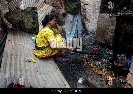 Gli abitanti delle Slum del Bangladesh hanno visto la ricerca dei loro beni domestici dopo un devastante incendio scoppiato nello slum di Mohakhali a Dhaka, Bangladesh, il 7 giugno 2021. Almeno 300 shanties sono stati eviscerati come il devastante fuoco che è scoppiato a Mohakhali slum a Dhaka. Foto Stock