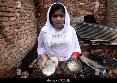 Gli abitanti delle Slum del Bangladesh hanno visto la ricerca dei loro beni domestici dopo un devastante incendio scoppiato nello slum di Mohakhali a Dhaka, Bangladesh, il 7 giugno 2021. Almeno 300 shanties sono stati eviscerati come il devastante fuoco che è scoppiato a Mohakhali slum a Dhaka. Foto Stock