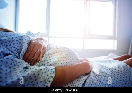 Primo piano della pancia di una donna incinta in ospedale Foto Stock