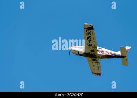 1978 Piper PA-28 aereo Cherokee Arrow III che vola in cielo azzurro sull'aeroporto di Southend, Essex, Regno Unito. Buona visibilità volo privato in VFR Foto Stock