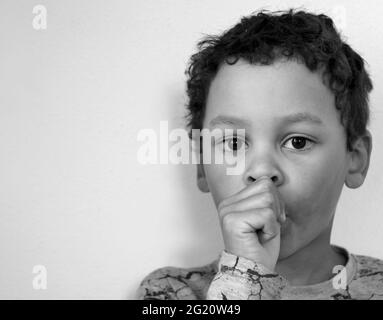 ragazzo succhiando pollice su sfondo bianco foto stock Foto Stock