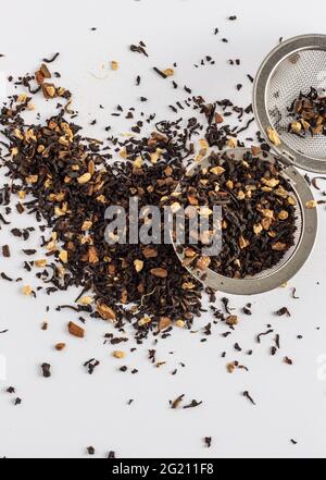 Foglie di tè Chai con piccoli pezzi di spezie su un infusore di tè Foto Stock