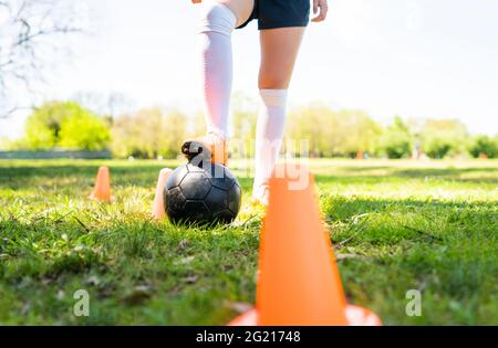 Giovane giocatore di calcio femminile che pratica sul campo. Foto Stock