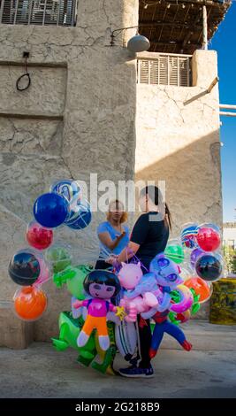 Un venditore di strada che vende palloncini su un angolo nella zona turistica al Seef a Dubai. Foto Stock