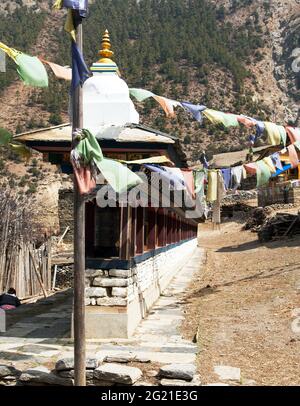 Preghiera buddista molti muri con ruote di preghiera e bandiere di preghiera nel villaggio nepalese, percorso di trekking circuito Annapurna, Nepal Foto Stock