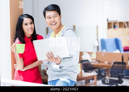 Due dipendenti determinati sorridono mentre pianificano una strategia aziendale di successo per il futuro dell'azienda Foto Stock