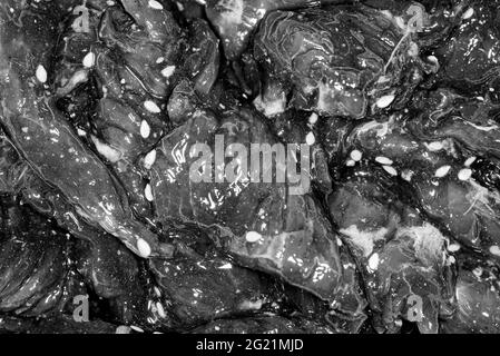 Fette di manzo marinate, luminose e succose, con spezie, olio e semi di sesamo Foto Stock
