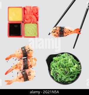 Bastoncini di pollo con gustosi sushi, insalata di alghe, salse e zenzero marinato su sfondo grigio Foto Stock
