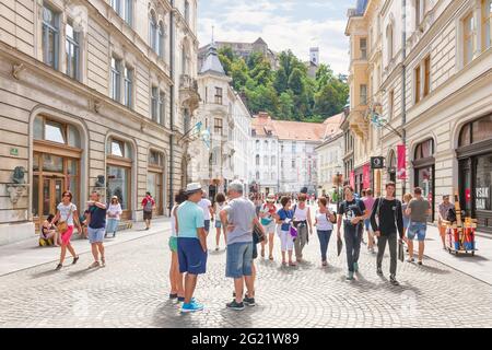 Lubiana, Slovenia - 15 agosto 2018: La strada Stritarjeva è un grande viale pedonale di ciottoli nel centro storico di Lubiana con vista sul castello Foto Stock