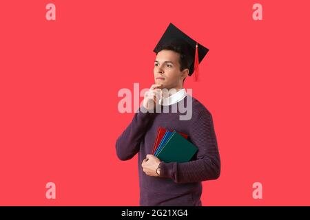 Studente di laurea maschile su sfondo a colori Foto Stock