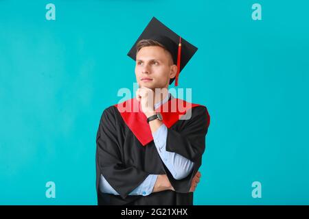 Studente di laurea maschile su sfondo a colori Foto Stock
