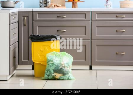 Sacchetto con bidone per rifiuti e rifiuti con logo di riciclaggio a casa Foto Stock