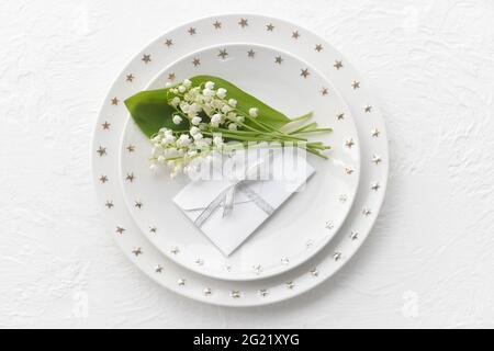 Bella tavola con fiori giglio-della-valle su sfondo chiaro Foto Stock