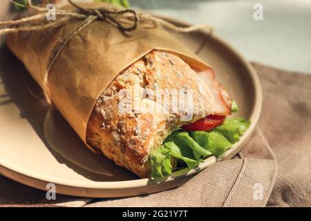 Piatto con gustoso sandwich di ciabatta sul tavolo Foto Stock