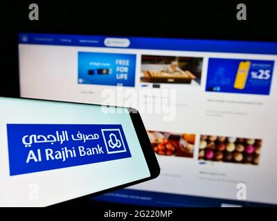 Telefono cellulare con logo della società finanziaria Saudita al Rajhi Bank sullo schermo di fronte al sito web aziendale. Mettere a fuoco il centro-destra del display del telefono. Foto Stock