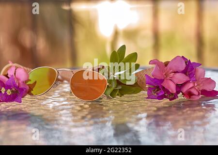 Surreal bougainvillea rosa brillante fiori in un cono gelato e occhiali da sole. Sfondo di vacanze estive. Spazio di copia. Foto Stock