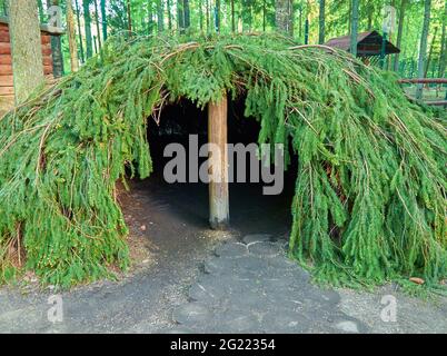 Una tenda fatta di rami di abete rosso in primo piano. Foto Stock