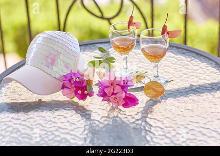 Cocktail estivi sfondo su sfondo verde luminoso con fiori rosa di bougainvillea. Berretto da donna brillante. L'estate inizia il concetto creativo. Foto di alta qualità Foto Stock