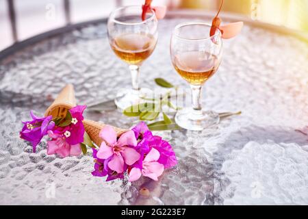 Cocktail estivi con fiori rosa di bougainvillea su un tavolo di vetro. Concetto di rinfresco. Estate fiori surreali luminosi e bevande fatte in casa. Spazio di copia. Foto di alta qualità Foto Stock