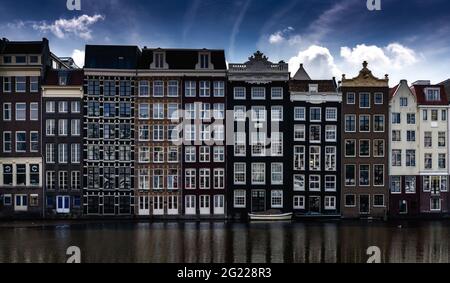 Amsterdam, Paesi Bassi - 19 maggio 2021: Vista delle case iconiche sul lungomare di Damrak nel centro di Amsterdam Foto Stock