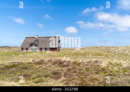 Sonderho, Danimarca - 29 maggio 2021: Tradizionale casa danese con tetto di paglia canna in un paesaggio di dune di sabbia costiera Foto Stock