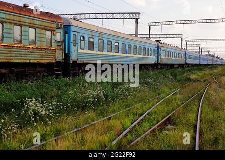 Trasporto - vista laterale sulle vecchie vetture ferroviarie passeggeri con i finestrini rotti. Foto Stock