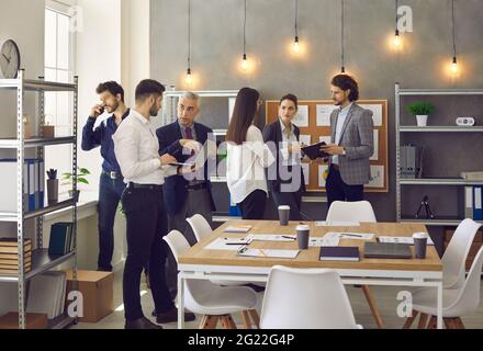 I colleghi di ufficio parlano al lavoro e discutono di un'idea di condivisione del piano strategico del progetto Foto Stock