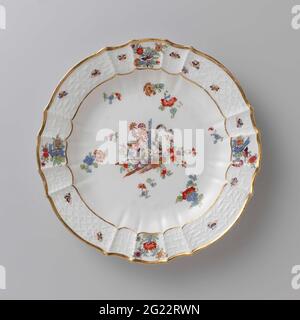 Piatto rotondo, dipinto con un decor kakiemon. Piastra rotonda in porcellana verniciata. La piastra è scanalata e presenta un bordo scalettato. La piastra è dipinta con una tigre che è stata girata intorno ad un gambo blu di bambù tra fiori, spruzzato blumen indiano, farfalle e rami su cui uccelli. Il bordo è decorato con il motivo 'Altbrandenstein'. La piastra è stata contrassegnata. Foto Stock