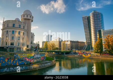 vienna, austria - OTT 17, 2019: Architettura a donaukanal al tramonto. Via d'acqua tra famosi edifici di urania osservatorio e torre uniqa in vigilia Foto Stock