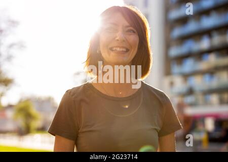 Ritratto di sorridente donna rossa in città Foto Stock