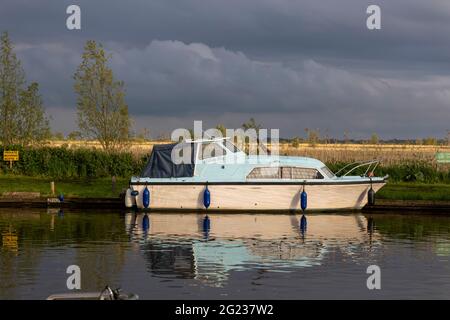 Barche ormeggiate e crociere in cabina sul fiume ANT a Ludham bridge, Norfolk Broads Foto Stock